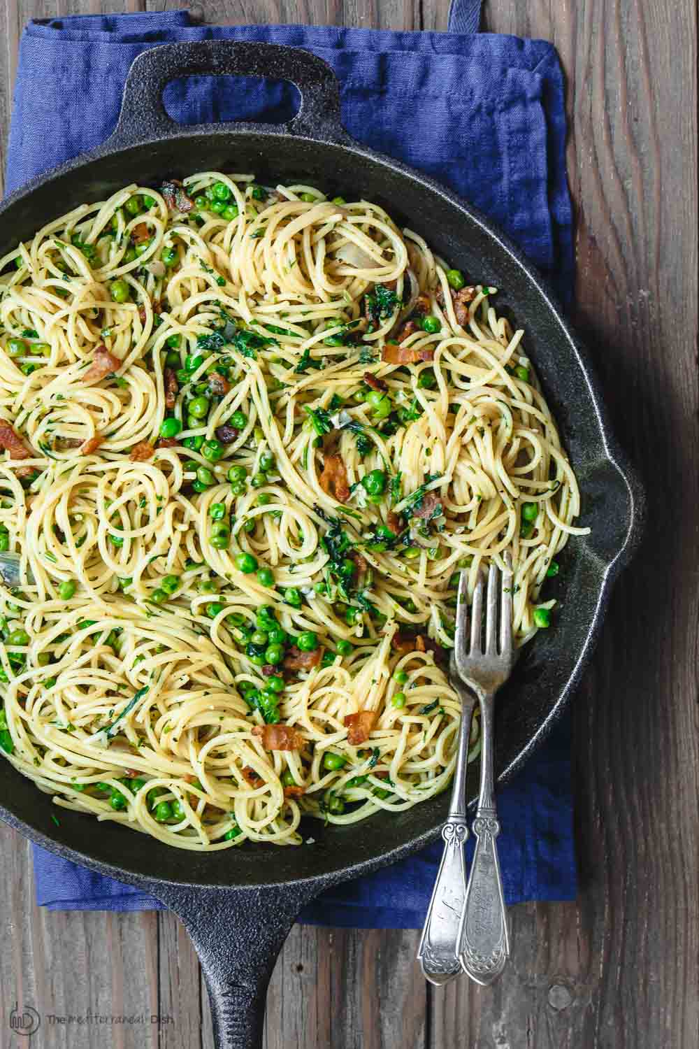 Simple pasta with pancetta and peas in a serving cast iron  pan