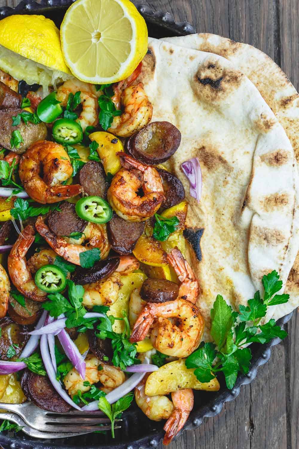 Close-up of contents of dish - chorizo, shrimp, squash and pita bread