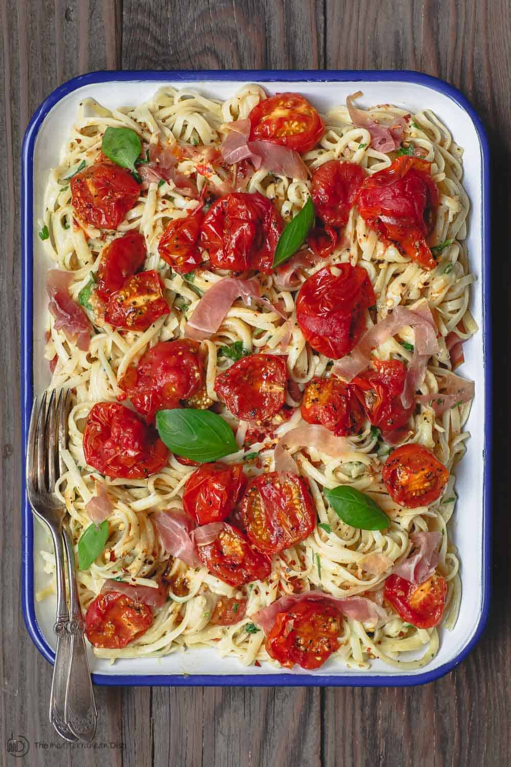 Carbonara Recipe with Roasted Tomatoes | The Mediterranean Dish. A lighter, and flavor-packed cabornara recipes with garlic roasted tomatoes and fresh herbs. You can add ribbons of prosciutto, if you like. A couple of tricks make a perfectly creamy carbonara. Recipe from themediterraneandish.com #pasta #pastarecipe #italianfood #mediterraneandiet #carbonara #easyrecipe