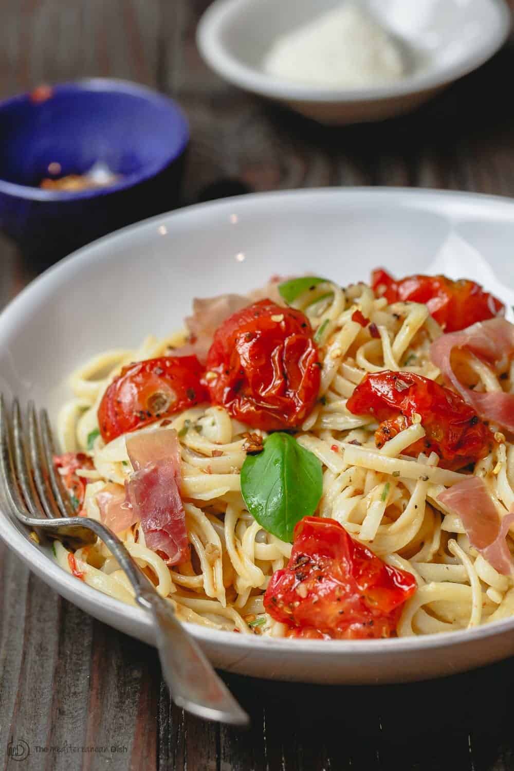 Carbonara Recipe with Roasted Tomatoes | The Mediterranean Dish. A lighter, and flavor-packed cabornara recipes with garlic roasted tomatoes and fresh herbs. You can add ribbons of prosciutto, if you like. A couple of tricks make a perfectly creamy carbonara. Recipe from themediterraneandish.com #pasta #pastarecipe #italianfood #mediterraneandiet #carbonara #easyrecipe