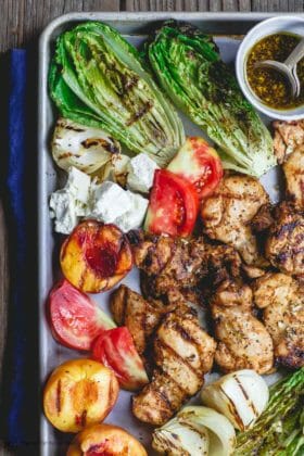 Grilled Harissa Chicken Recipe | The Mediterranean Dish. Easy, flavor-packed Mediterranean grilled chicken. Add grilled vegetables and peaches or serve with your favorite salad. Get the recipe on themediterraneandish.com #grilledchicken #mediterraneanchicken #mediterraneandiet #easydinner #heatlhyrecipes #grilledpeaches #grilledlettuce