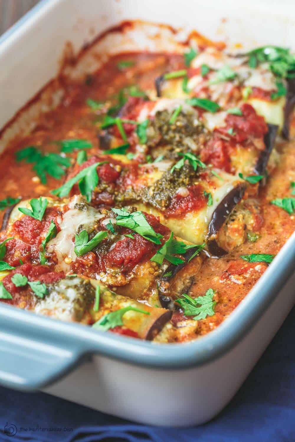 Eggplant Rollatini Recipe | The Mediterranean Dish. Flavor-packed, healthy eggplant rollatini that is perfect for dinner or as an appetizer. The secret is in the tasty rollatini filling with part-skim ricotta, basil pesto, and fresh parsley. Recipe from themediterraneandish.com #eggplant #mediterraneanfood #mediterraneandiet #italianfood #eggplantrollatini #glutenfreerecipes