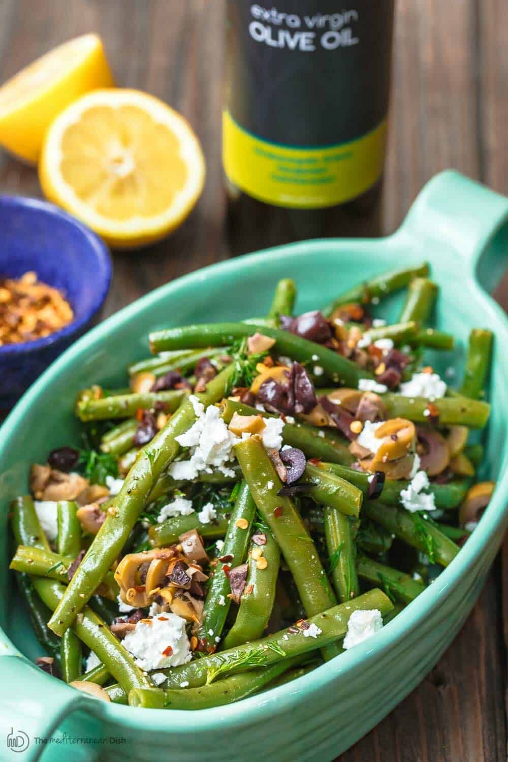 Greek Green Bean Salad Recipe | The Mediterranean Dish. Perfectly tender, flavor-packed green bean salad prepared Greek style. A garlicy, zesty dressing pulls it together, and a sprinkle of feta and chopped marinated olives take it to a new level of delicious. Get the easy recipe on themediterraneandish.com #greenbeans #greekfood #greekrecipe #mediterraneanrecipe #mediterraneandiet