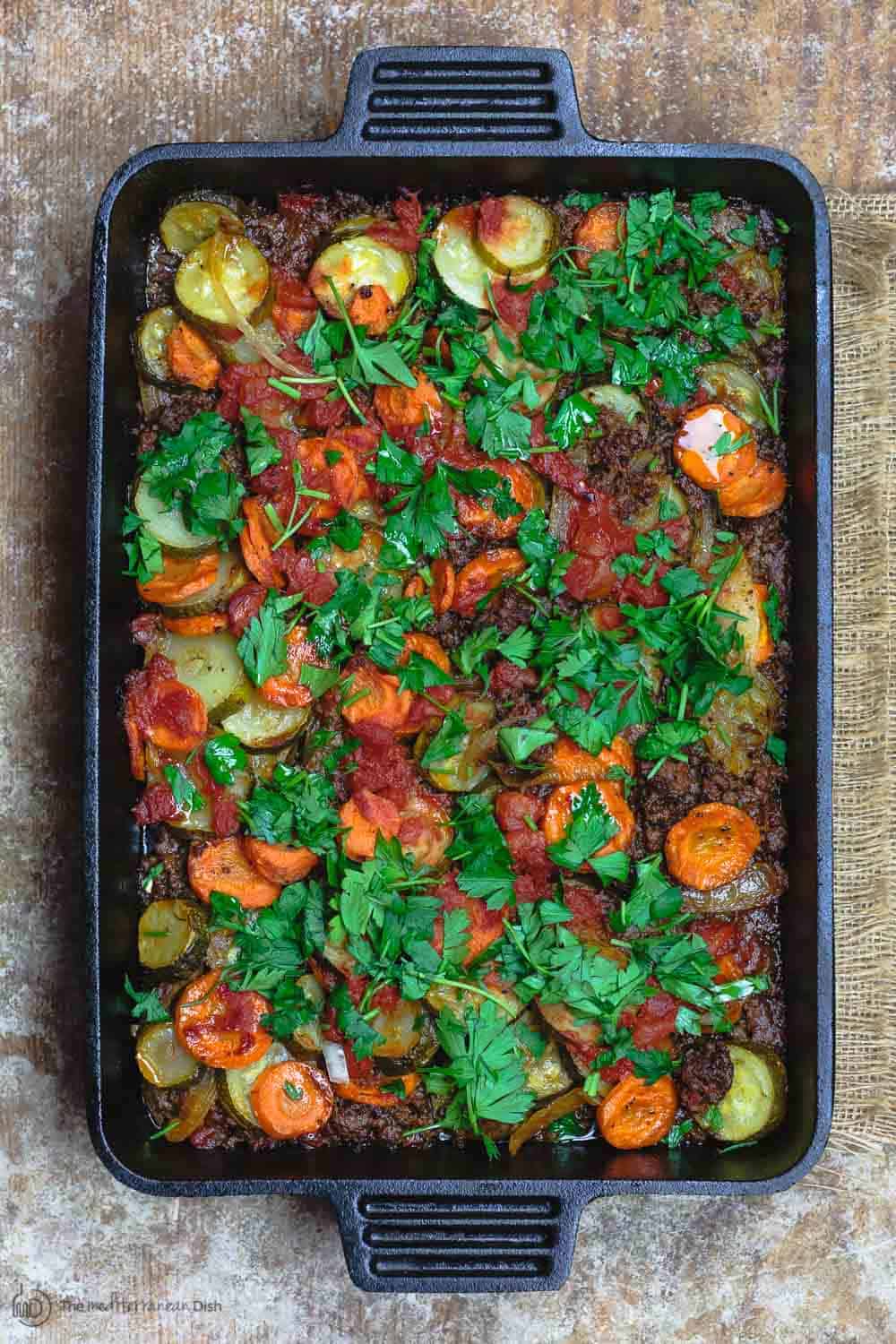 Mediterranean Style Zucchini Casserole | The Mediterranean Dish. Low carb zucchini casseroles with layers of zucchini, carrots, onions and a perfectly spiced meat sauce. Aromatics, warm Mediterranean spices, and fresh herbs make all the difference. See the full recipe on themediterraneandish.com #mediterraneandiet #zucchini #casserole #lowcarb #keto