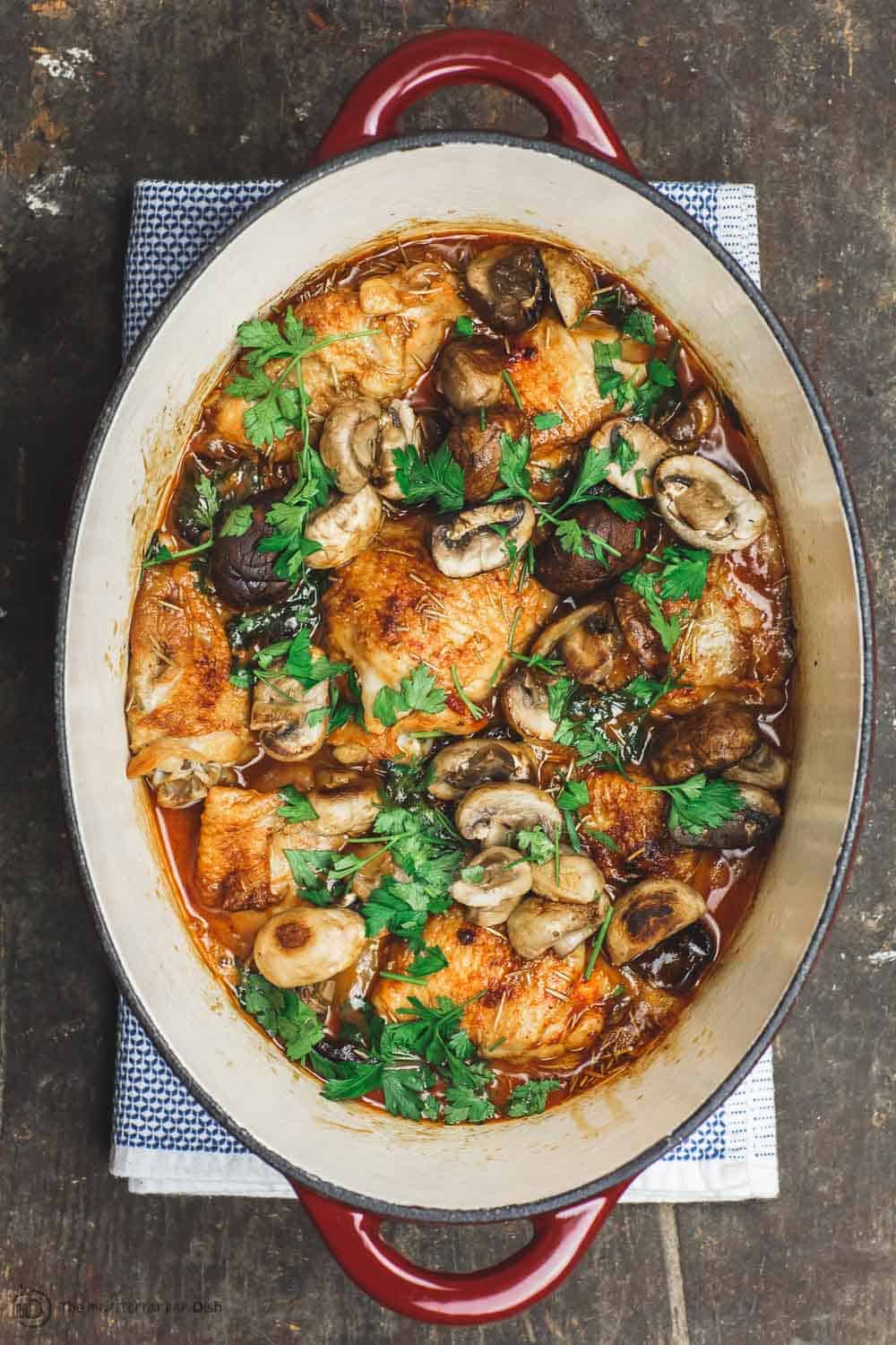 Wine braised chicken thighs with mushrooms and shallots in Dutch oven 