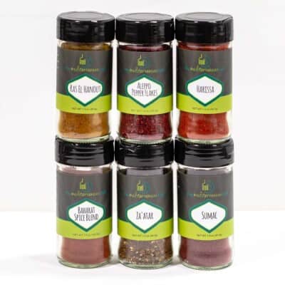 exotic six pack of spices includeing ras el haout, aleppo pepper flakes, harissa, baharat spice blend, za'atar, and sumac.