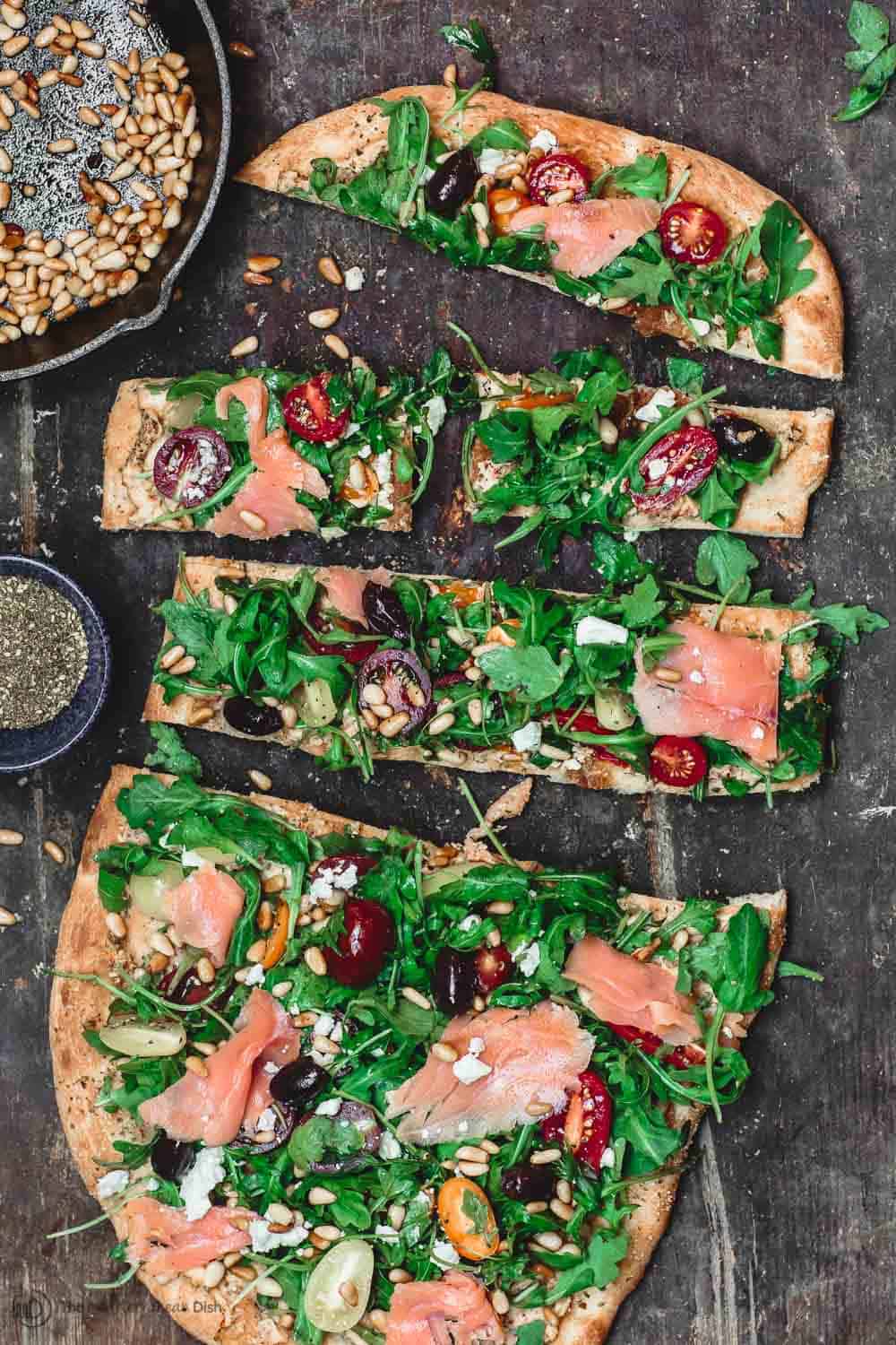 Sliced Flatbread with arugula and smoked salmon to serve as appetizer