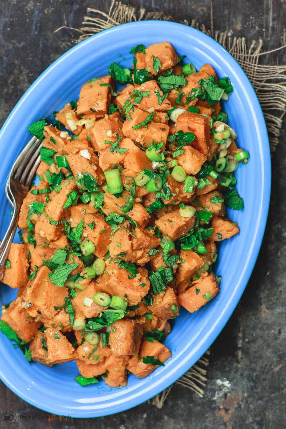 Simple sweet potato recipe served with fresh herbs, garlic, and scallions