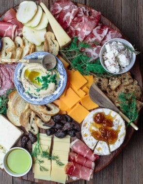To make the best cheese board, you need a variety of four cheeses, meats, and accompaniments