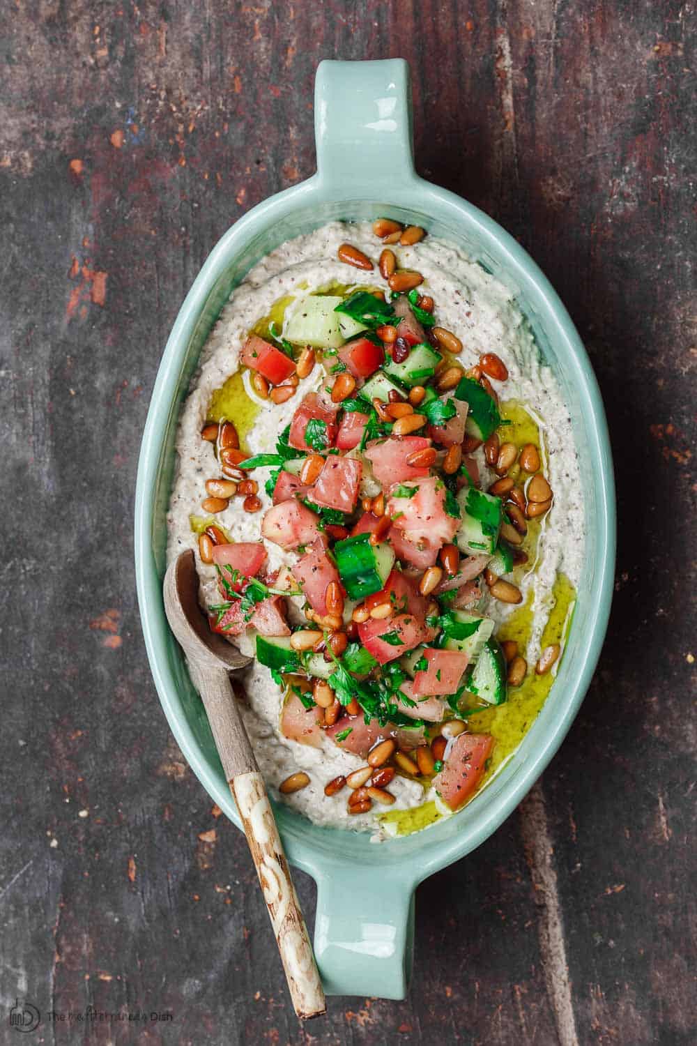 Smoky Eggplant Dip, Baba Ganoush, topped with Mediterrnean salad of cucumbers, tomatoes, and parsley