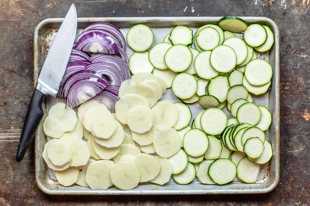 Sliced rounds of zucchini, potatoes, and red onion