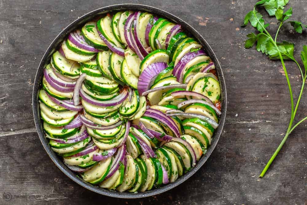 Round pan is ready with assembled veggies in rows 