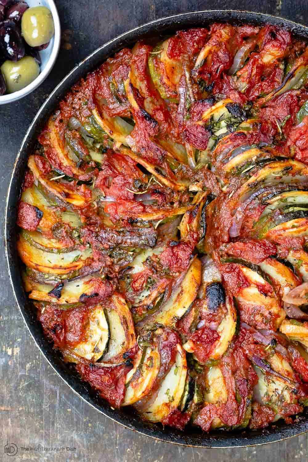 Briam. Traditional Greek Roasted Vegetables with potatoes, zucchini, red onions, tomatoes and extra virgin olive oil