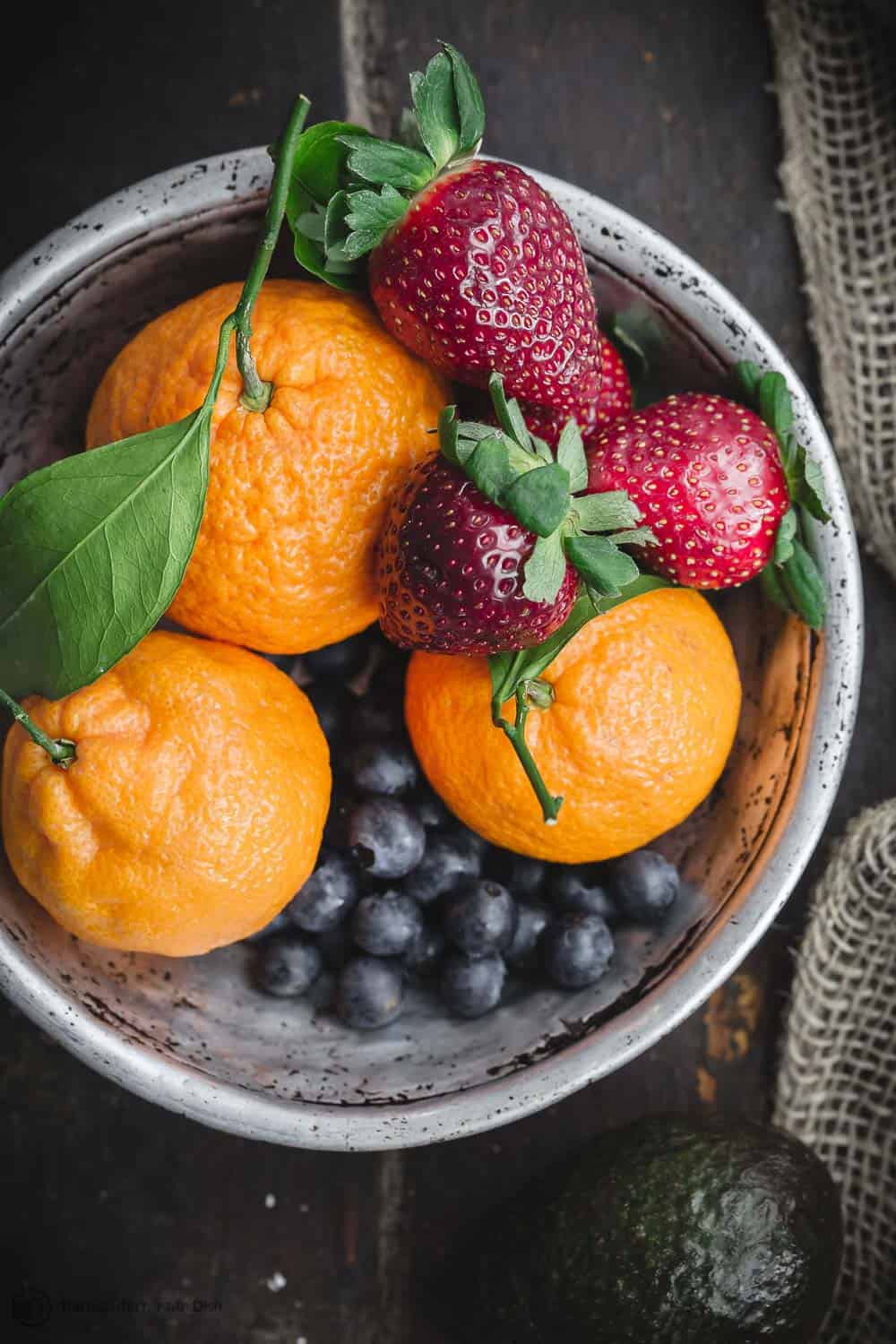 Fresh fruits including citrus fruit and berries in a bowl for a Mediterranean diet snack