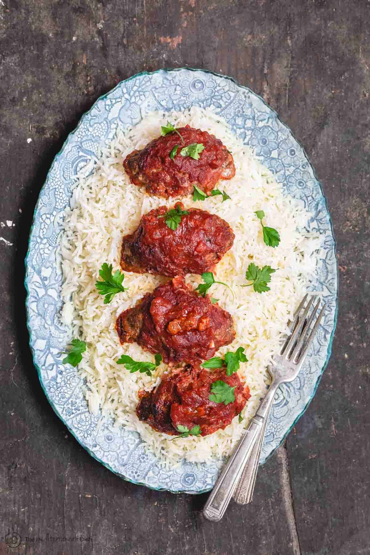 Baked Meatballs with red sauce arranged on top of white rice