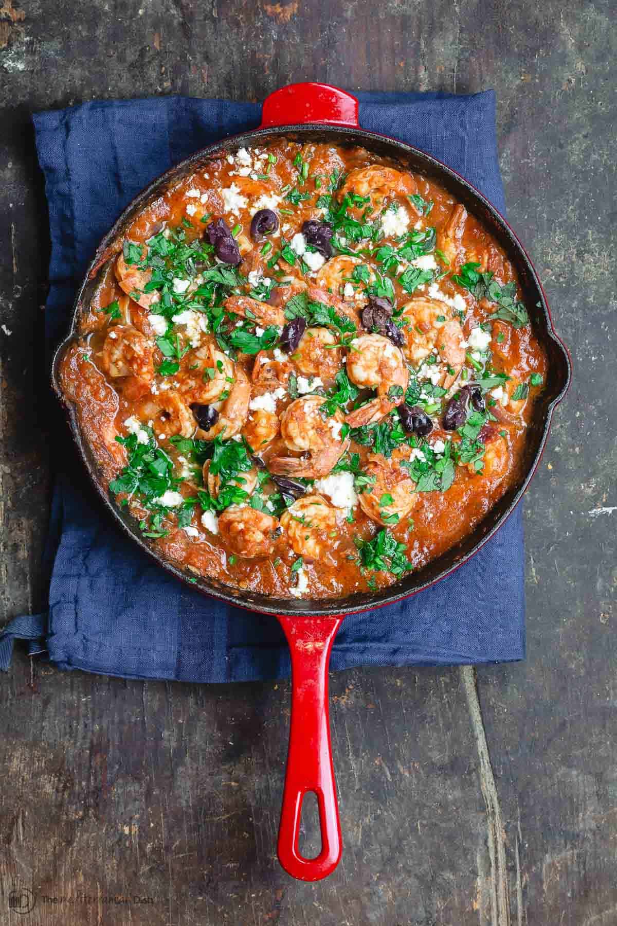 Shrimp in tomato sauce, served family-style in cooking skillet.