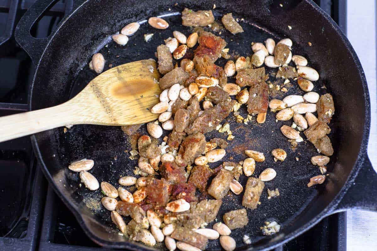 Whole wheat bread and almonds cooking in skillet with spices