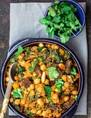 Chickpea Stew Garnished with Cilantro. More cilantro in a small bowl on the side