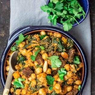 Chickpea Stew Garnished with Cilantro. More cilantro in a small bowl on the side