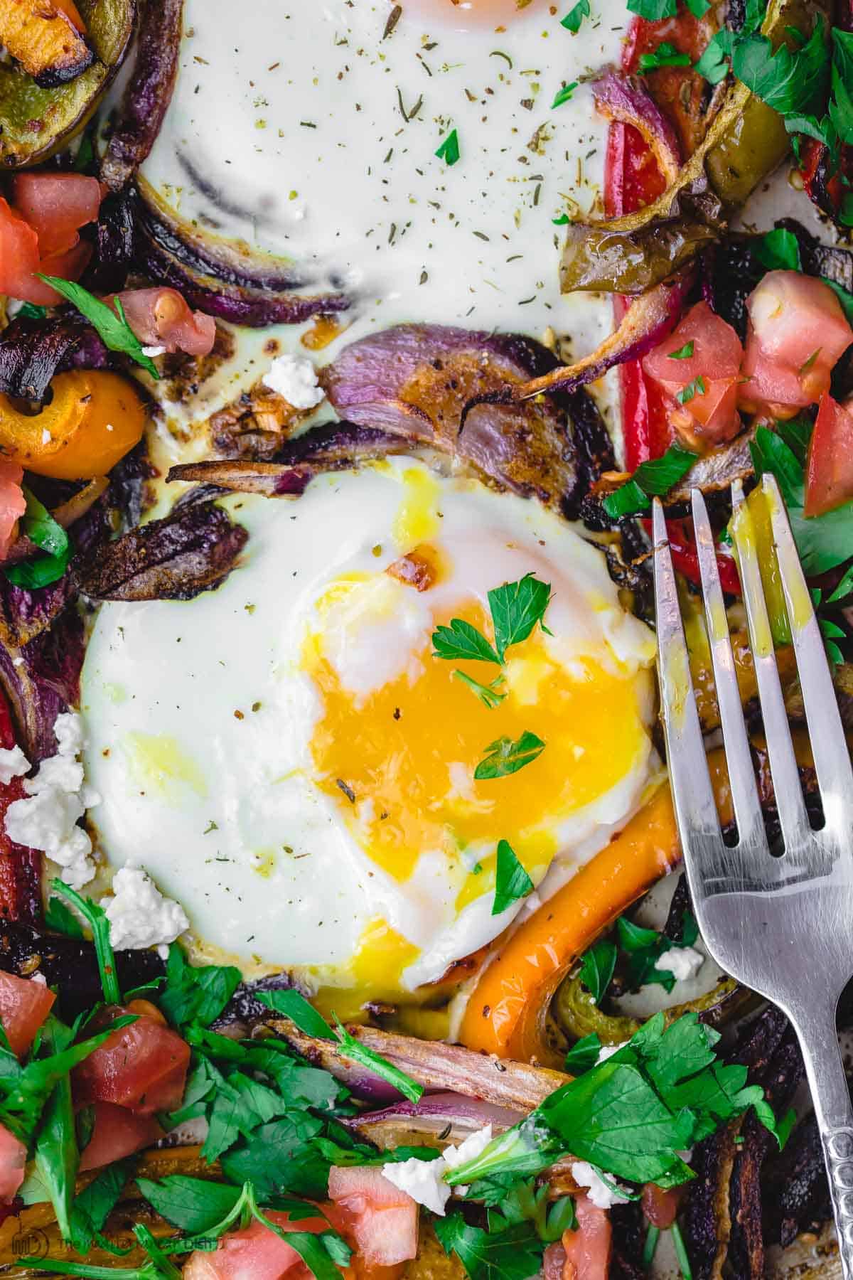 Running egg yoke over roasted veggies on a plate