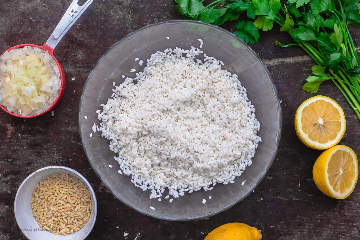 Some Greek lemon rice ingredients. Rice, orzo, fresh lemon, chopped onions and fresh parsley