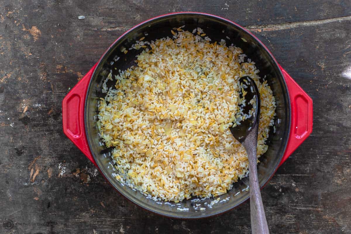 Orzo and rice are sauteed with onions, garlic and olive oil to start the Greek rice recipe