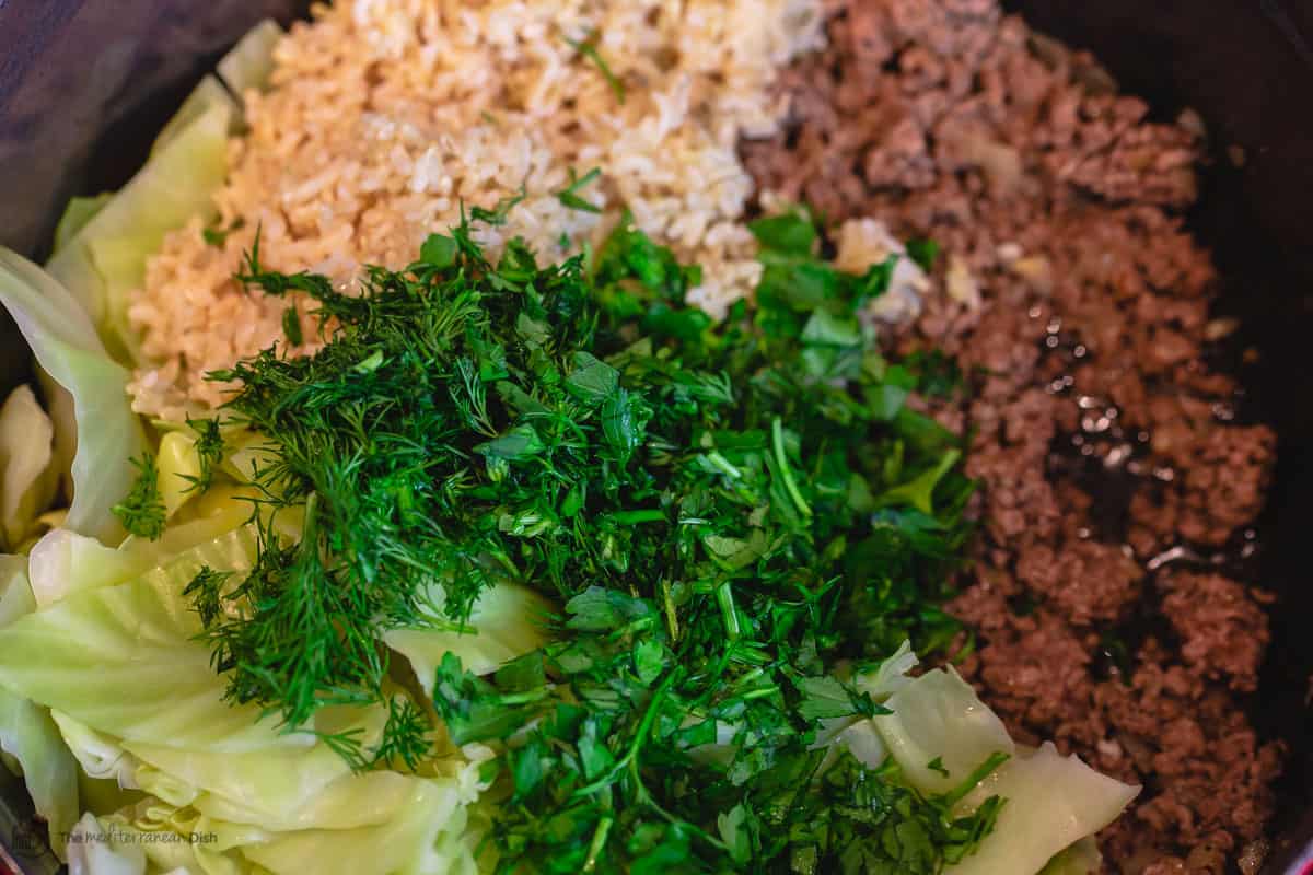 To make unstuffed cabbage rolls, a large pot with ground beef, cooked brown rice, cooked cabbage leaves, herbs and fresh herbs