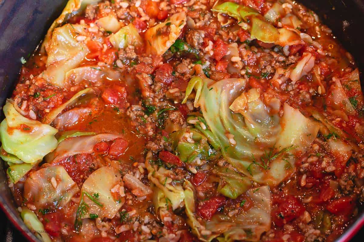 Diced tomato, tomato sauce and water are added to the large pot of unstuffed cabbage rolls ingredients