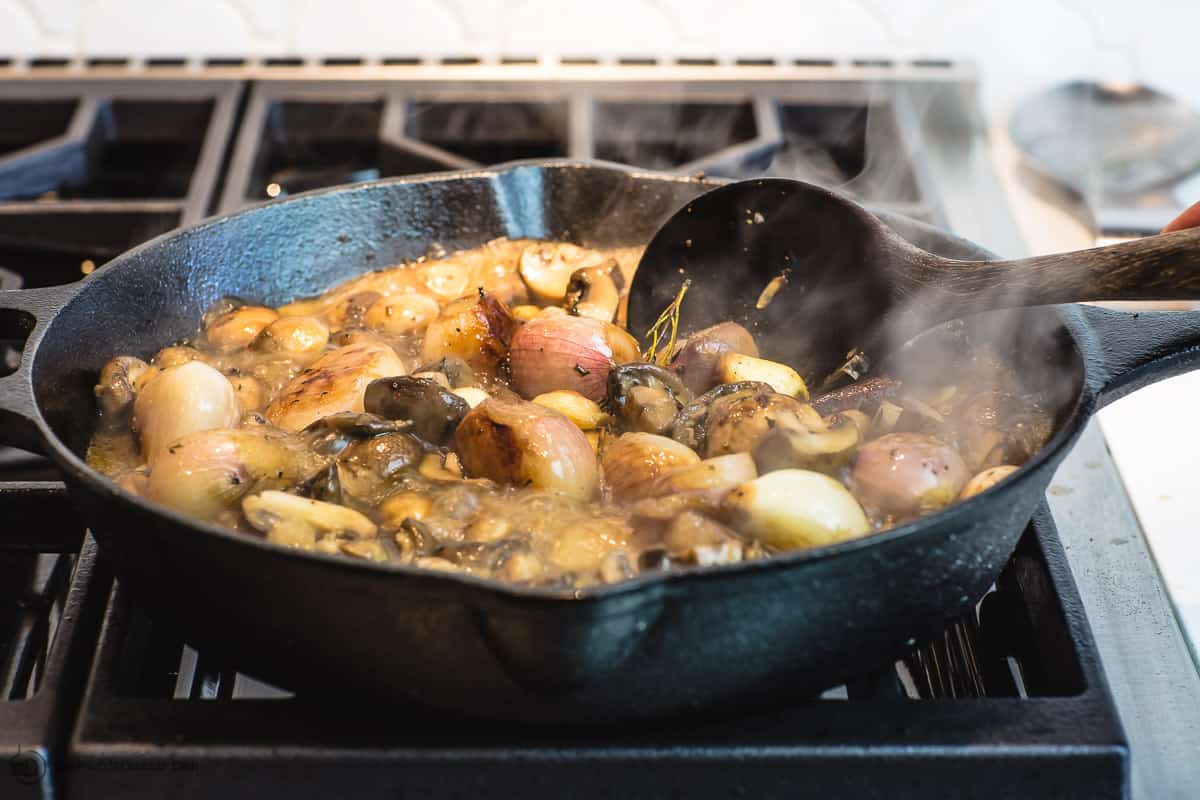 mushrooms simmering in broth with shallots, garlic, and spices