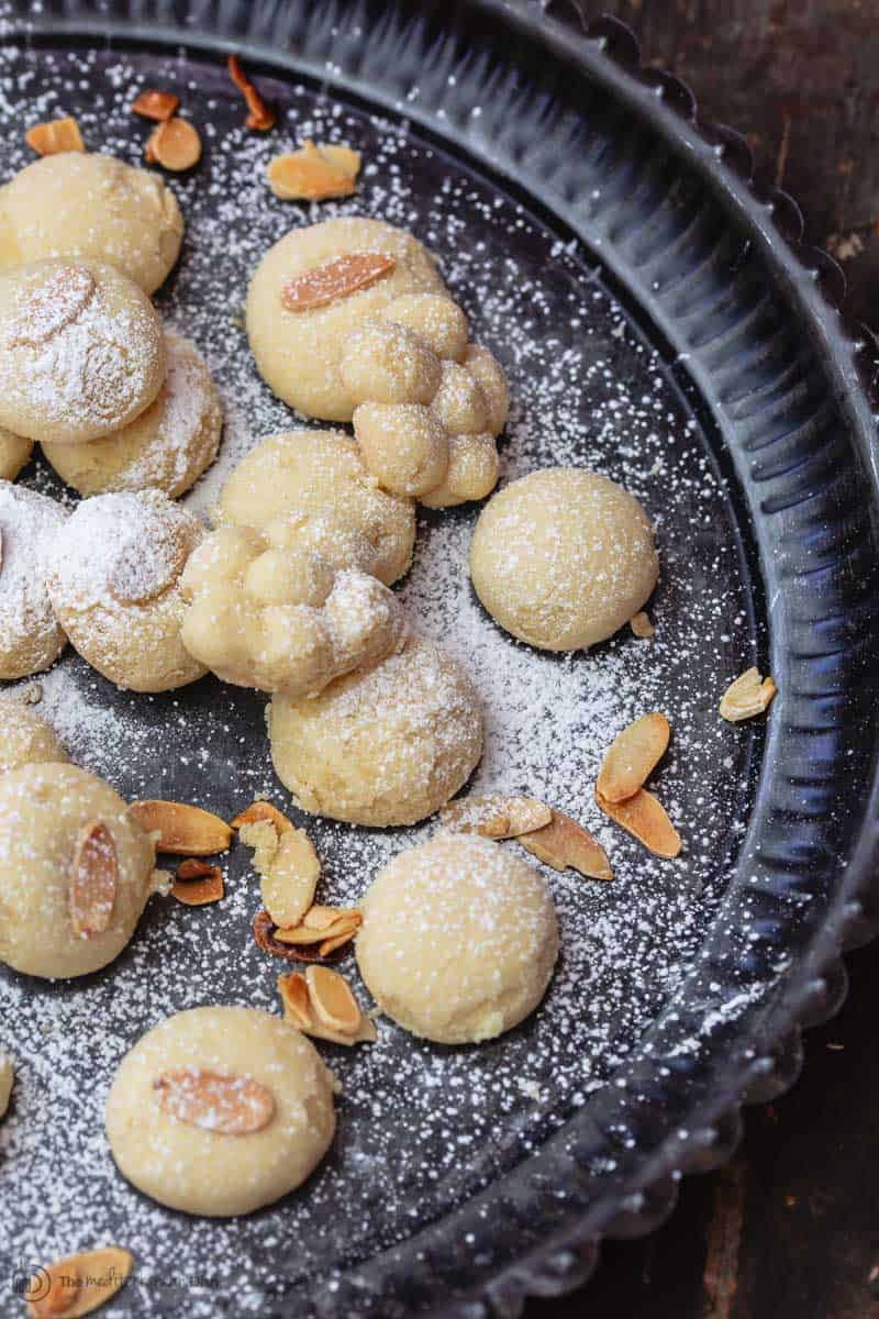 Bite size butter cookies, garnished with powdered sugar and almonds