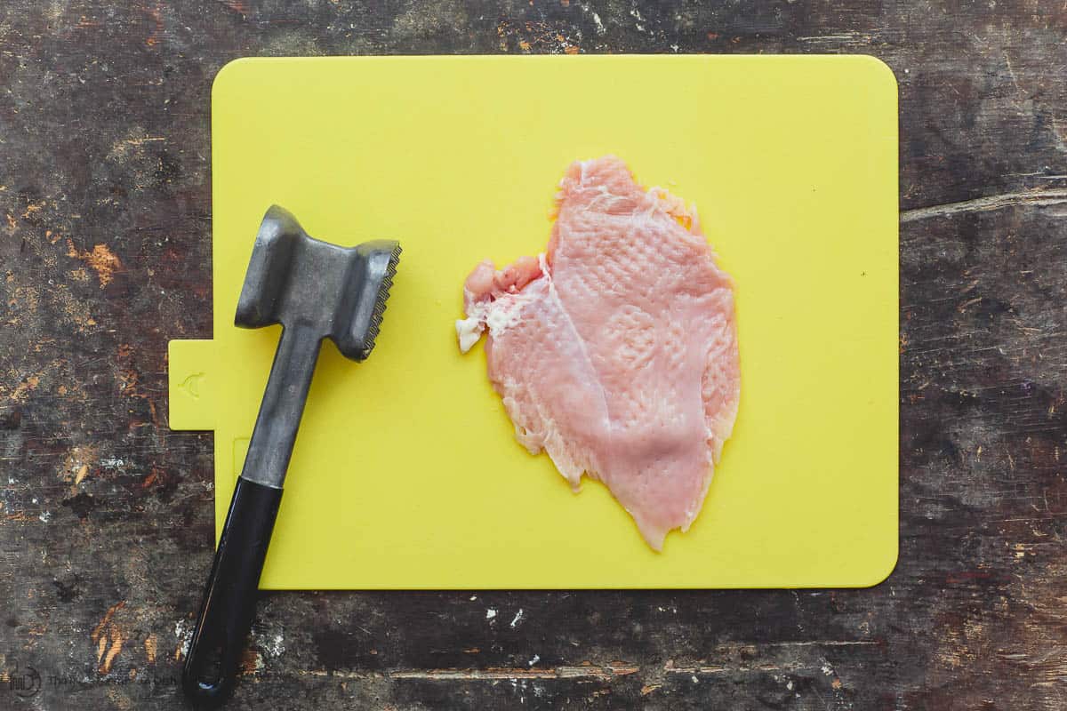 Chicken breast pounded using a kitchen mallet 