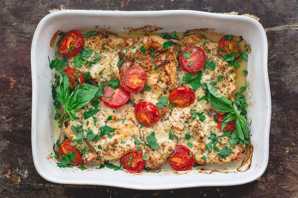 Finished Italian baked chicken, garnished with parsley and basil