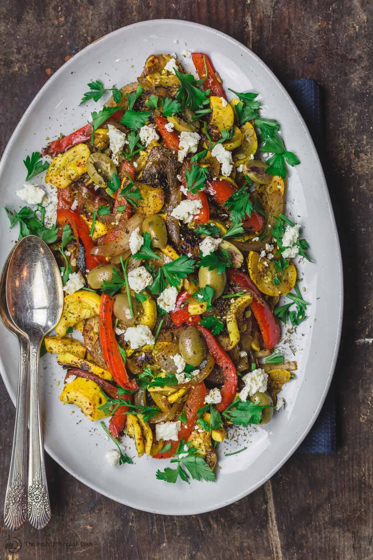 Sauteed Yellow Squash with Sweet Onions and bell peppers. Served with a garnish of feta cheese, olives and parsley