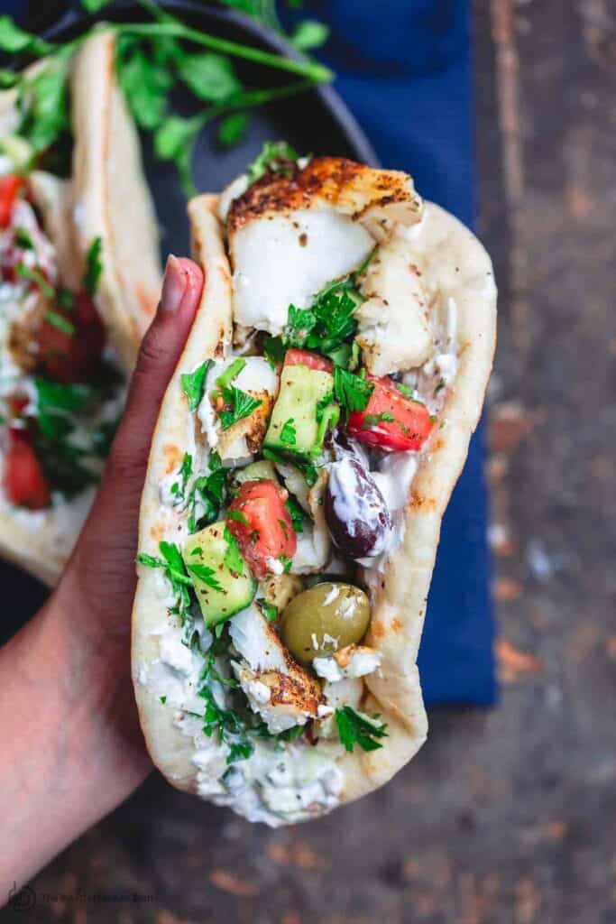 Grilled cod assembled gyro-style in pita wraps