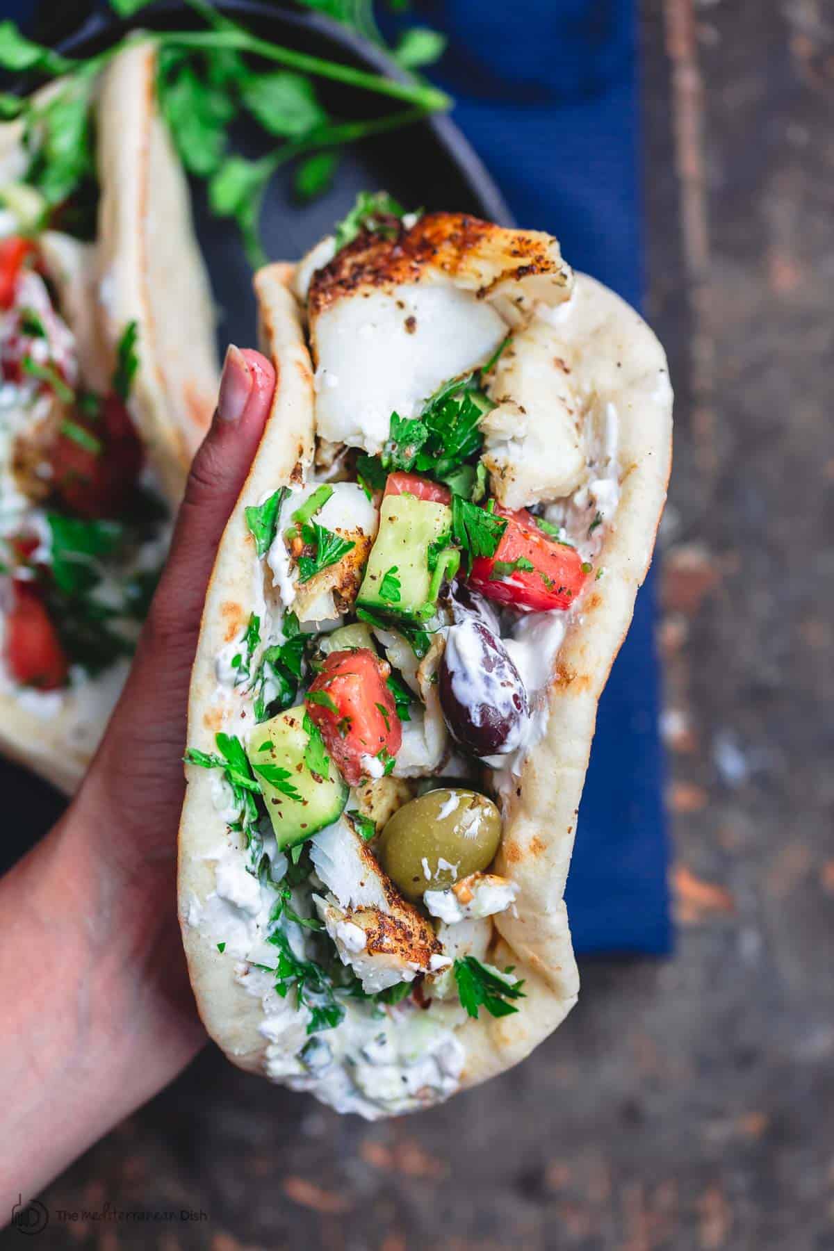 Grilled cod assembled gyro-style in pita wraps 