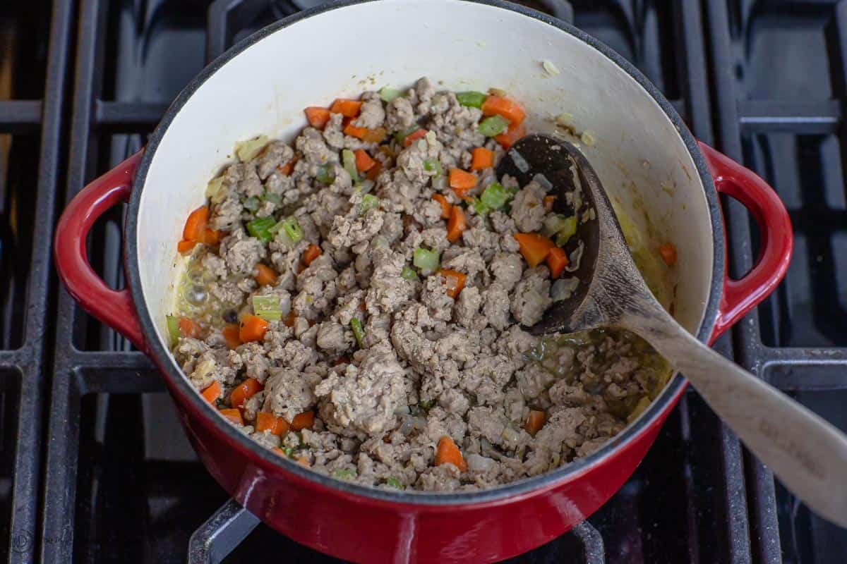 Ground meat is added to the onions, celery and carrots