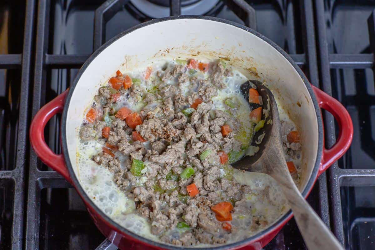 Meat mixture with whole milk added. Milk is bubbling away