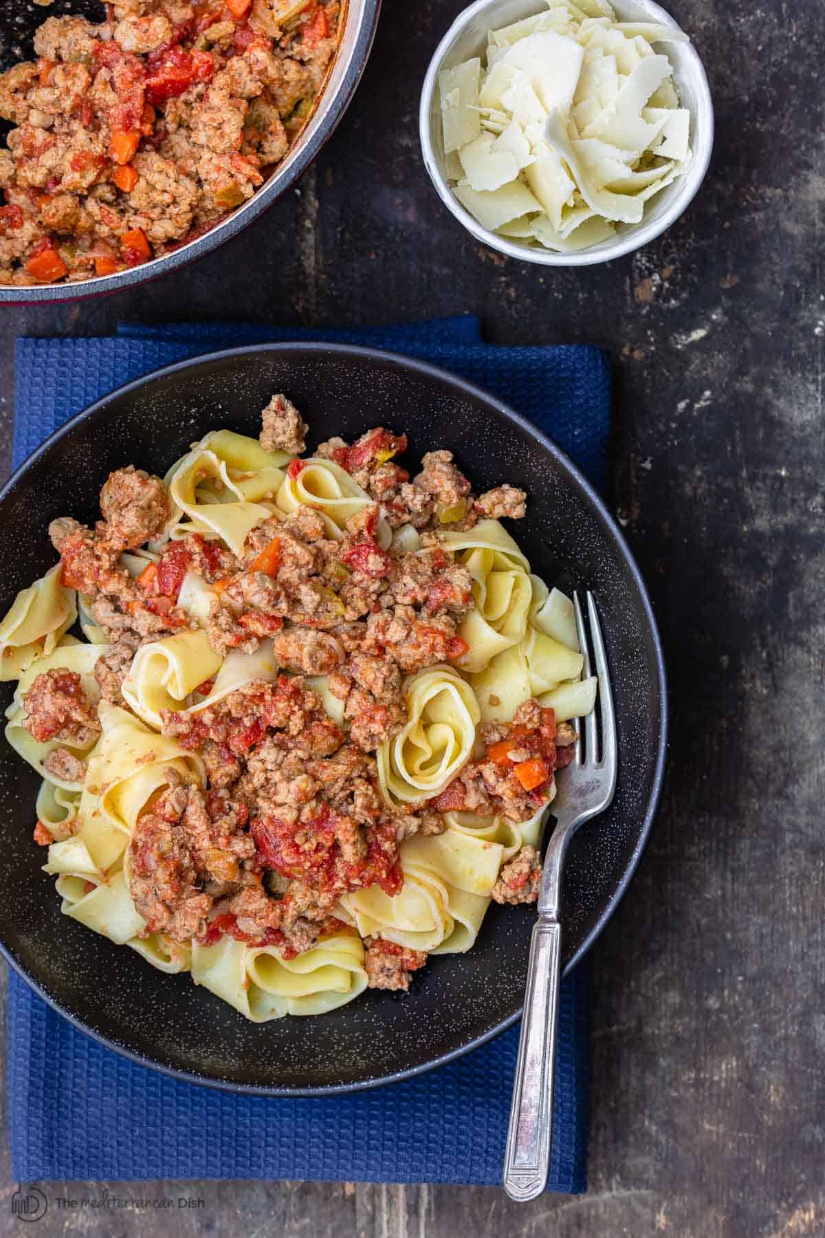 Turkey Bolognese Sauce served with pasta and a side of parmesan cheese