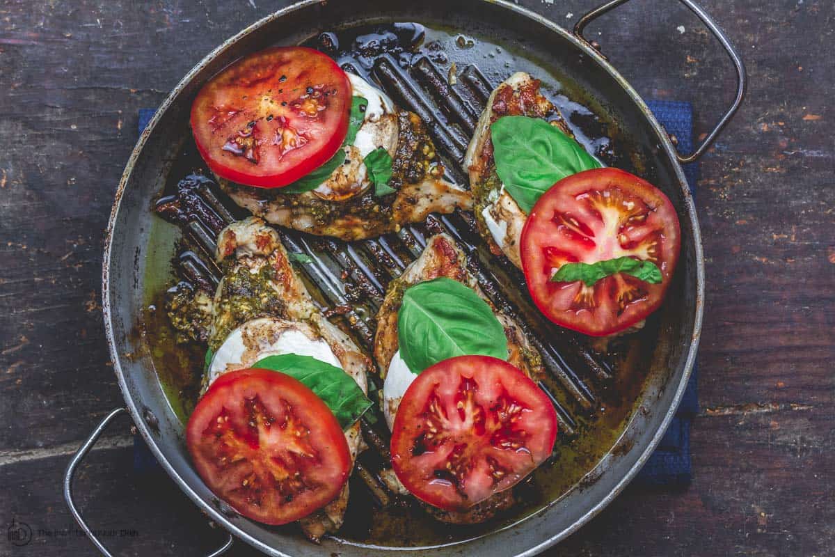 Finally, add fresh basil and tomato slices to complete caprese chicken