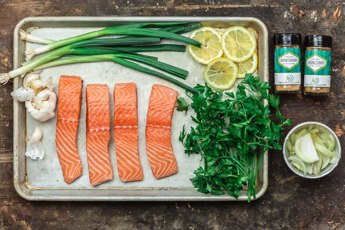 Steamed salmon ingredients. Salmon fillets, garlic, onions, fresh herbs and lemon