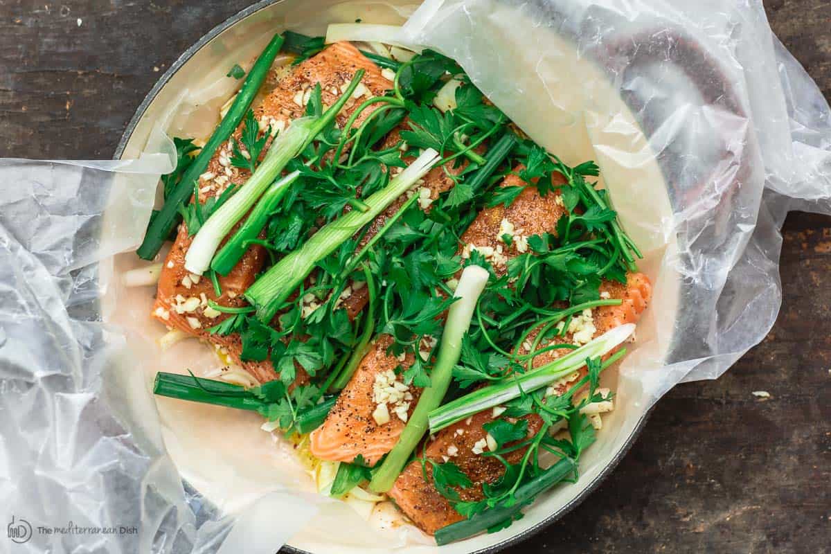 Uncooked salmon now topped with garlic, fresh parsley and green onions