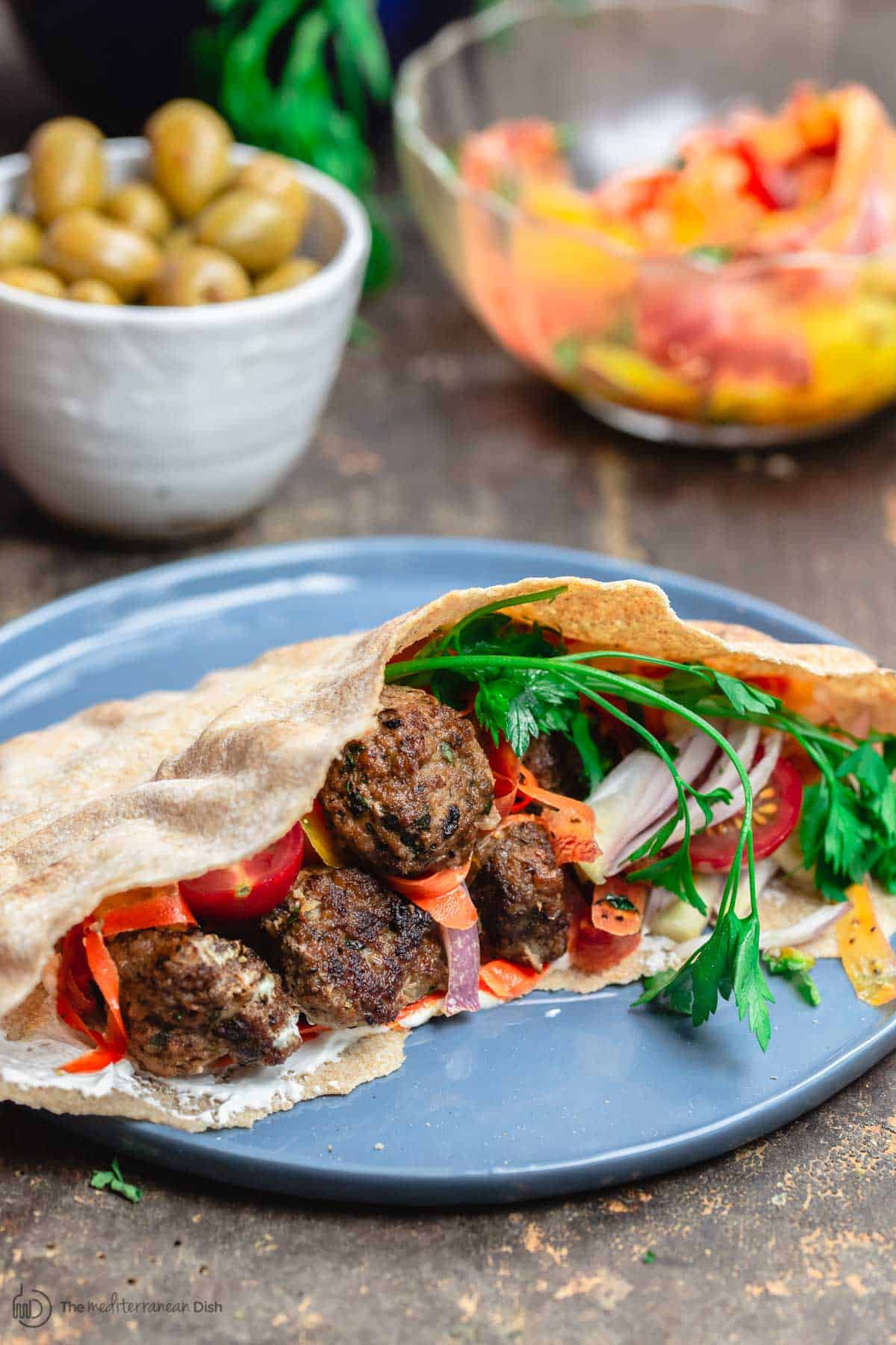 Moroccan Meatballs served in Pita Pockets with Fresh Vegetables and Carrot Salad. A side of Olives