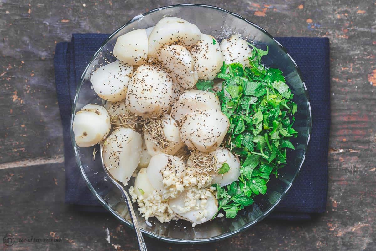 Boiled potatoes in a bowl with fresh parsley and spices
