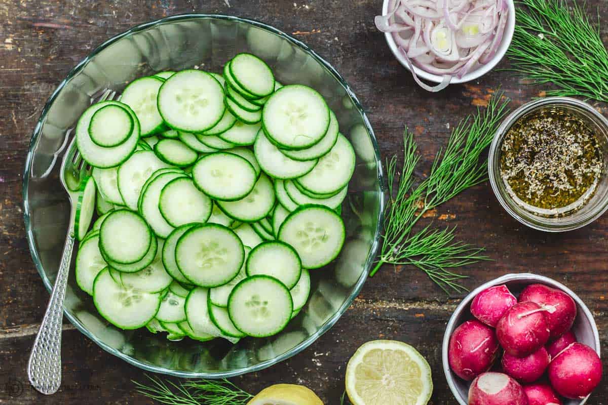 Cucumber salad ingredients, including cucumber slices, radish, and onions