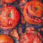 Greek stuffed tomatoes with rice and ground beef on a sheet pan