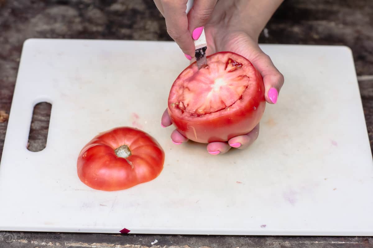Pairing knife used to loosen tomato flesh from its edges