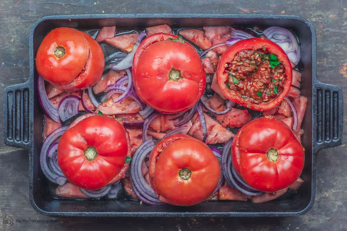 Stuffed tomatoes in baking pan before cooking