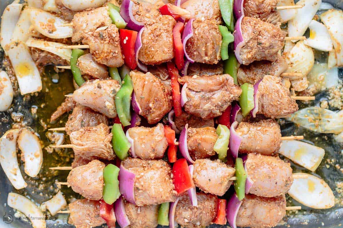 Cubed chicken pieces marinated and skewered with vegetables