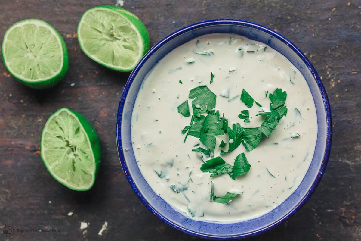 Tahini sauce with parsley. Lime juice to the side