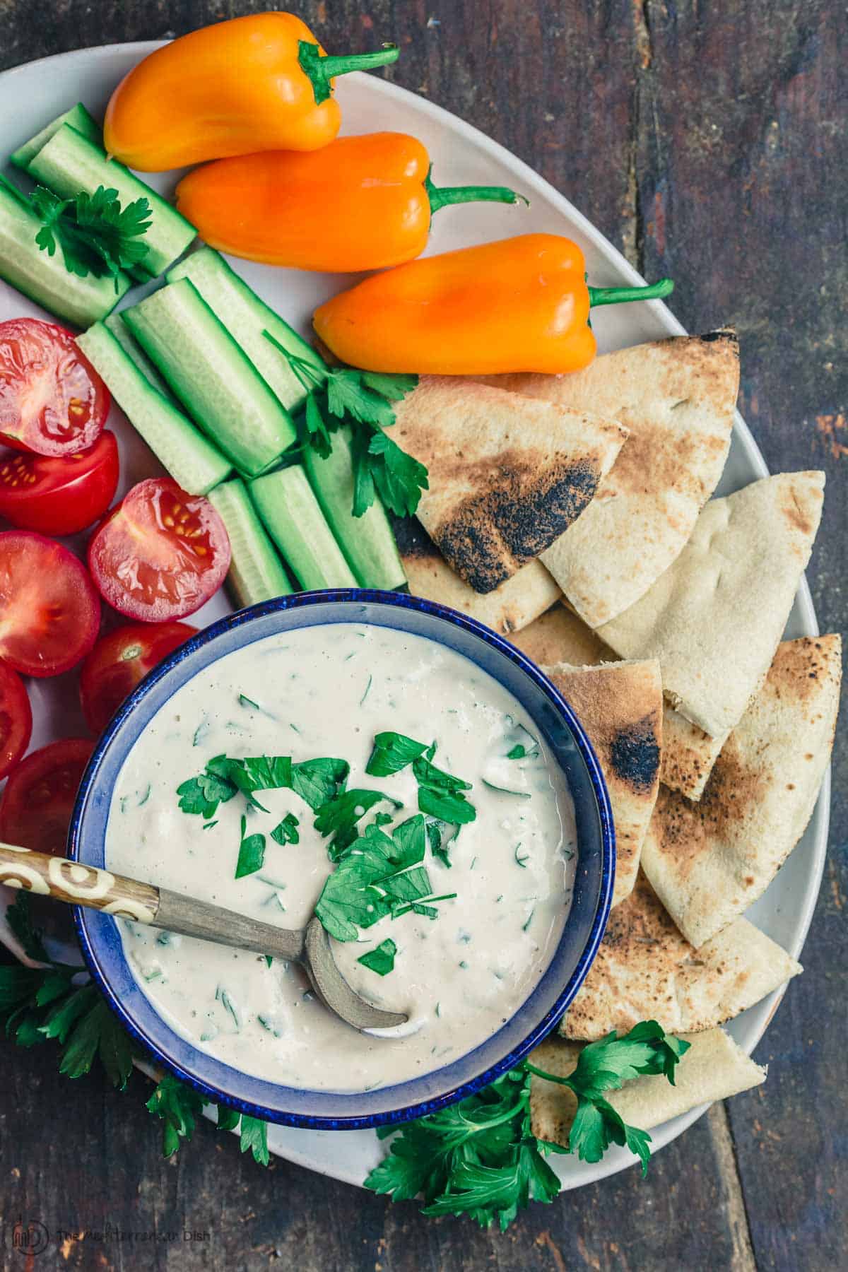 Tahini Sauce Platter with fresh vegetables and pita wedges